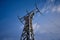 High-voltage metal power pole over a blue sky