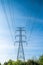 High voltage pole with blue sky background, Electric transmission line system for large industrial plants.