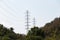 High voltage post or transmission tower in nature day light. High-voltage tower bright blue sky with bright sunlight background.