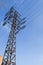 High-voltage power line 110 kV, metal support, wires, insulators, against the blue sky, vertical shot