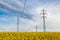 High voltage power line in oilseed rape field and beautiful sky