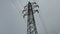 High-voltage power line tower against the sky, electrical wires.