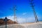 High voltage power lines in desert area. Road sign