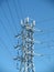 High Voltage Power Lines intersect at a large metal Utility pole with cell tower