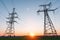 High-voltage power lines passing through a green field, on the background of a beautiful sky