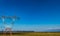 High voltage power lines on power pylons on a large grass field