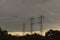 High Voltage Power Lines in Silhouette on Dark and Ominous Evening Sky