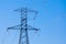 a high-voltage power transmission line, in the photo, a power line support against a blue sky