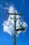 High voltage pylons against a blue sky with white clouds.