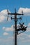 High voltage pylons against a blue sky with white clouds.