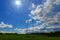 High voltage pylons - Blue sky with clouds and sun in nature. Concept for technology and industry. Further rising electricity and