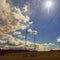 High voltage pylons - Blue sky with clouds and sun in nature. Concept for technology and industry. Further rising electricity and