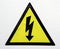 High voltage sign. Yellow triangle with black flash silhouette lighthing and black border. Isolated