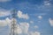 High voltage tower and electric line over cloudy blue sky