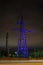 High voltage towers lightened with violet light in evening