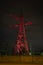 High voltage towers lightened with white and red light in evening