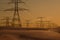 High voltage towers in row in the dessert at sunset