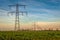 High voltage towers with thick hanging power cables in a rural landscape in the Netherlands