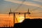 High-voltage transmission lines with electric supports at sunset.