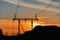 High-voltage transmission lines with electric supports at sunset.