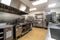 high-volume kitchen with a variety of tools and equipment, including commercial appliances and large sinks