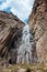 high waterfall, cliff and rocks, bottom view of a mountain waterfall, nature, landscape in the mountains