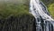 High waterfall with fast water streams flows among cliffs