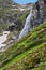 High waterfall and flowering rhododendron in the mountains