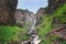 High waterfall Giraffe among the rocks on the Shinok river taiga and forest