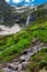 High waterfall and green hill in the mountains