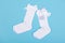 High white children`s socks with big bows for festive clothes on a blue background top view