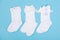 high white children\\\'s socks with big bows for festive clothes on a blue background top view
