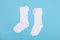 high white children\\\'s socks with big bows for festive clothes on a blue background top view