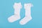 high white children\\\'s socks with big bows for festive clothes on a blue background top view