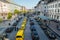 High wide angle city view of many yellow and black taxis in line.