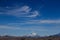 High wispy cirrus clouds filling the blue sky in Patagonia. With a glacier covered peak in the foreground