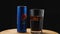 Highball glass with Pepsi and ice, next to an aluminum Pepsi can on a black background. The camera flies around