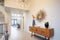 highceiling entryway with a modern chandelier and console table