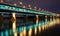 Highlighted bridge at night and reflected in the water.