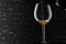 Highlighted wine glass with pouring alcohol drink in the dark