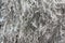Highly detailed background texture of gray fur made of synthetic animal long wavy and curly hair