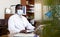 Highly qualified african american doctor in a protective mask types on a computer in the resident's office