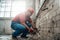 Highly skilled worker handling a brick wall on a large construction site