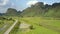 Highway across fields on swampy land and mountains aerial