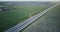 Highway aerial panorama with field and village. Drone 4K panning tilt shot. Logistics transportation network industry.