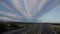 Highway with cars, windmills and vineyards at dusk