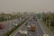 Highway in China with billboards and haze in sky.