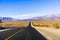 Highway crossing Death Valley National Park, Panamint Mountain Range in the background, California