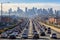 A highway filled with lots of traffic next to tall buildings in a big city