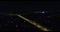 Highway with flowing traffic through an urban area at night aerial view